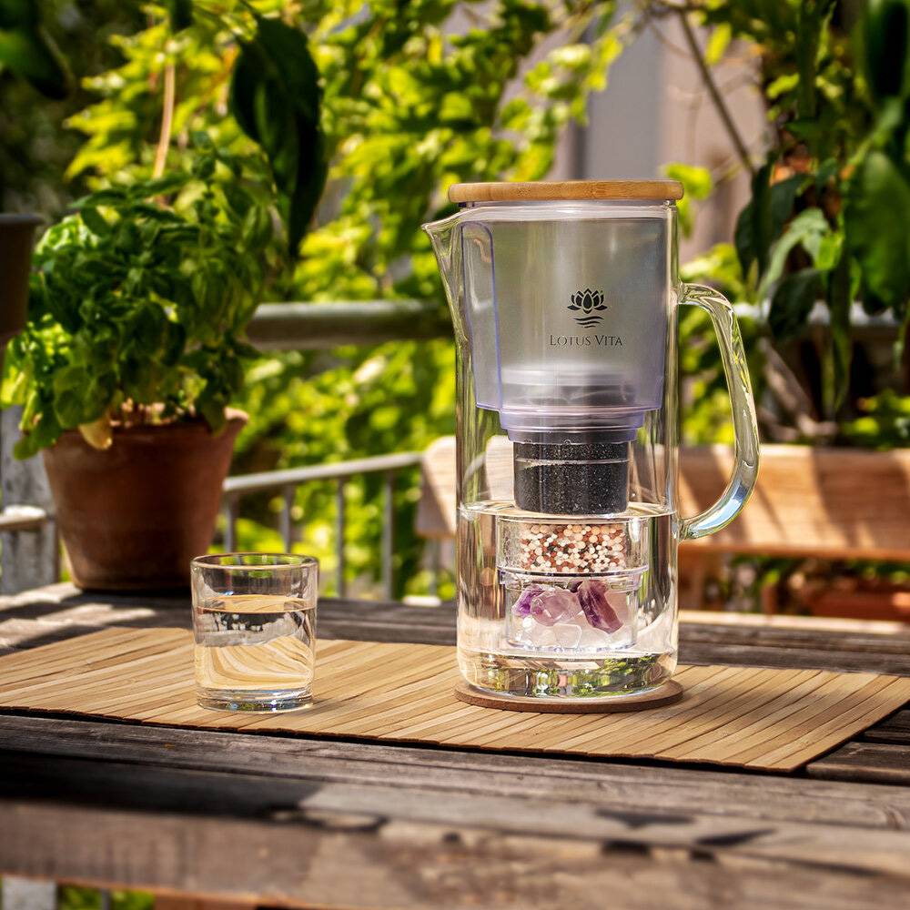 Wasserfilter Glaskanne Enya mit Bambusdeckel 1,4L - Natura Plus am Balkon auf dem Tisch